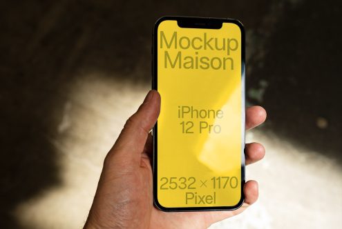 Hand holding iPhone 12 Pro mockup with yellow screen, resolution details, ideal for app design presentation, digital asset for UI designers.