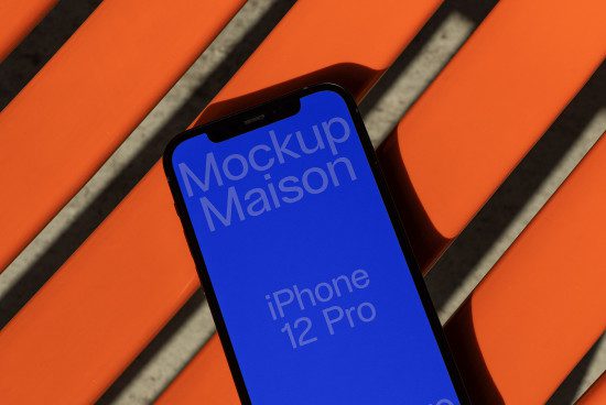 Smartphone mockup on orange bench, digital asset for design showcasing iPhone 12 Pro screen for app display, graphics, and templates.