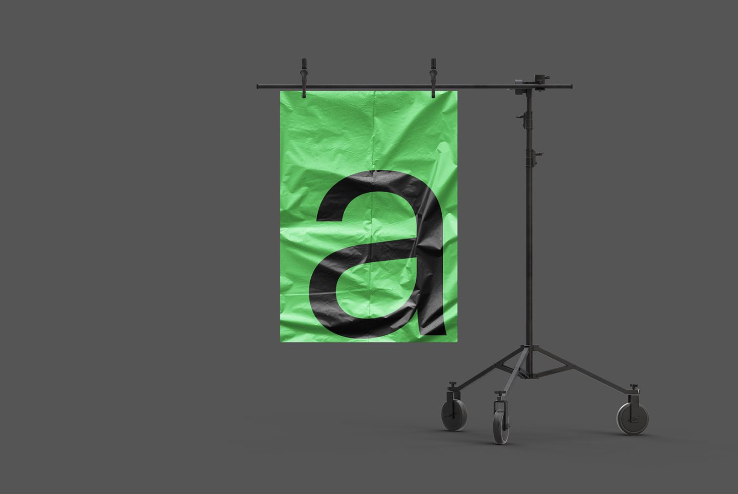 Crumpled green banner mockup on a stand with a large black ampersand symbol, isolated against a gray background, for graphic design presentations.