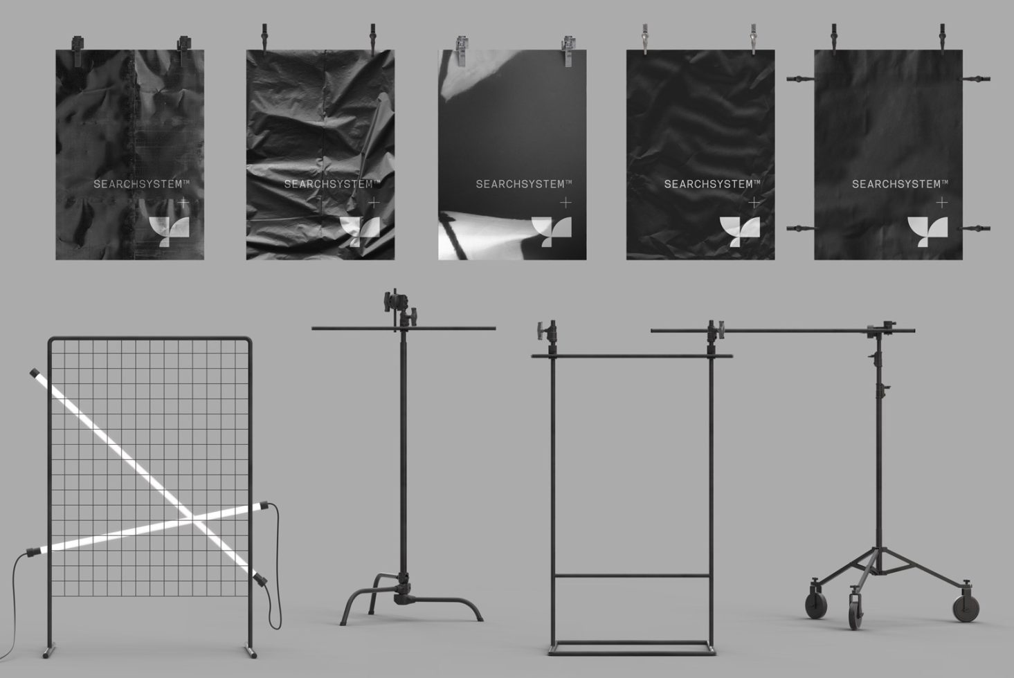 Poster mockups displayed in a studio setting with metal clamps, featuring monochrome designs, ideal for graphic presentations and branding.