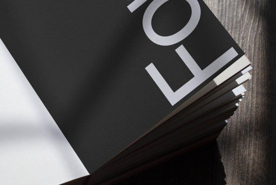 Close-up of a stack of black magazines with a visible modern typeface on the cover, ideal for design mockups and presentations.