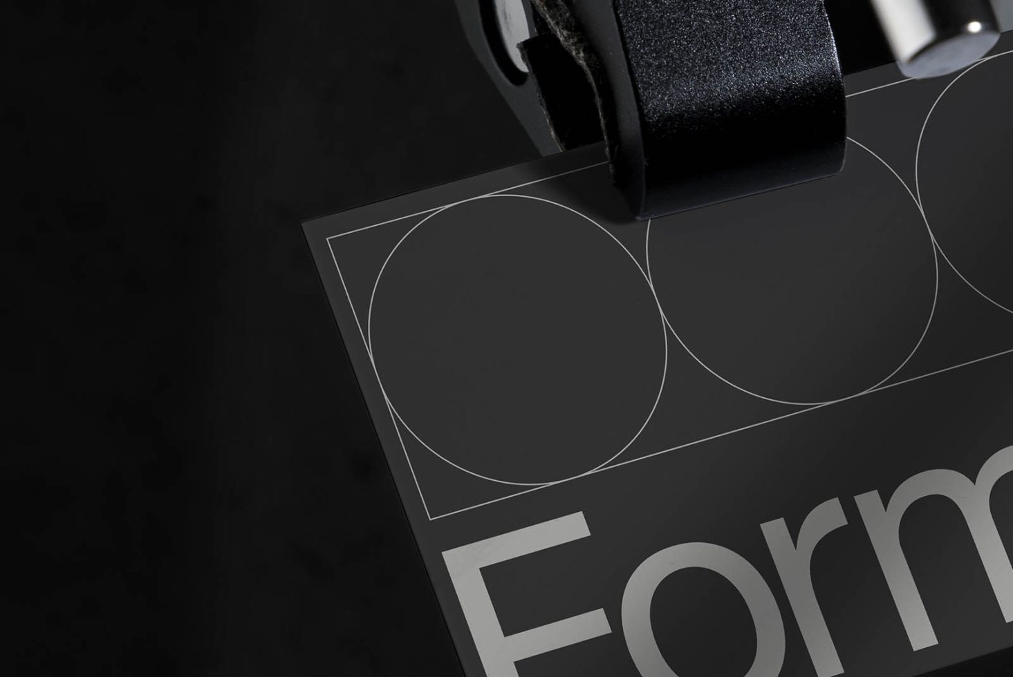 Close-up view of elegant typography design print on black card with tape, ideal for showcasing graphic design and font styling.