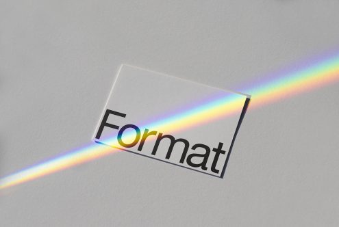 Clear business card mockup with rainbow light effect on textured paper for graphic designers.