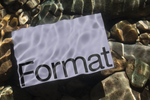 Submerged paper mockup with word Format on riverbed with clear water and pebbles, ideal for presenting design templates and graphics.