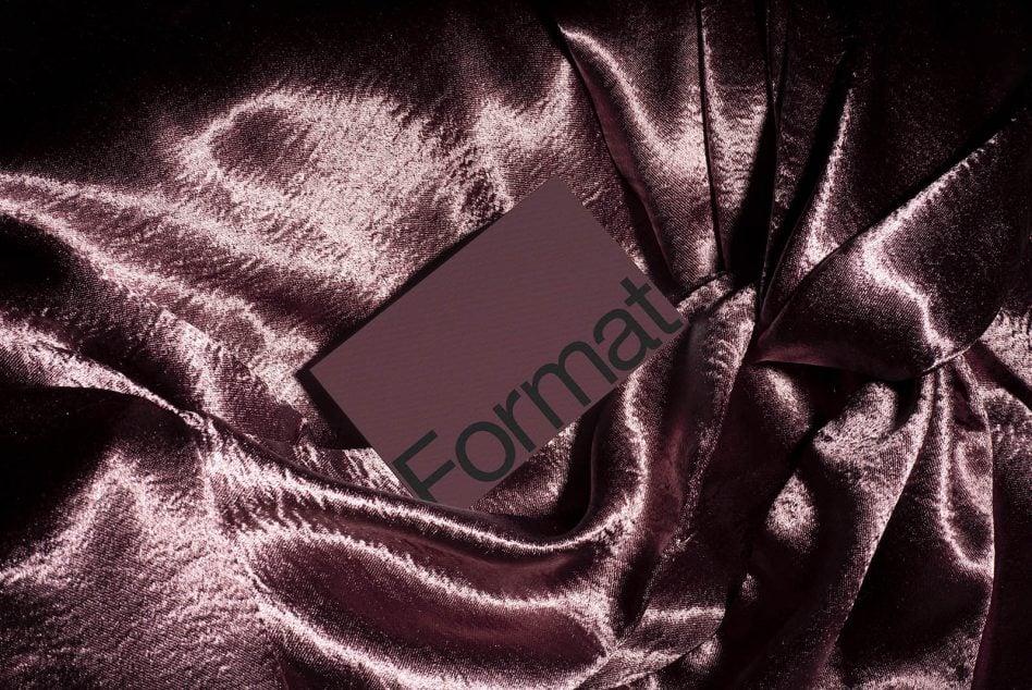 Mauve business card nestled in folds of sparkly pink silk material