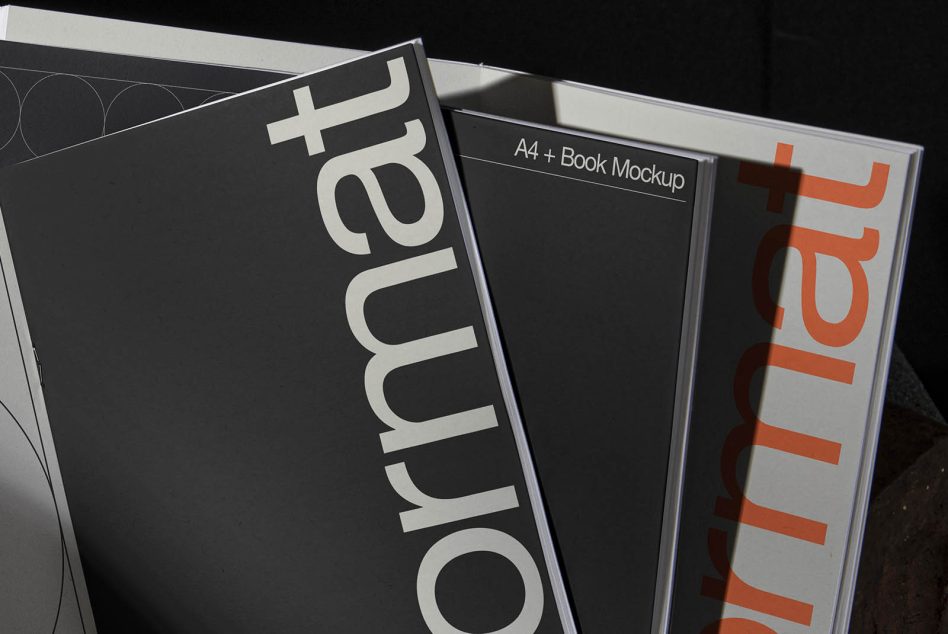 A4 plus book mockup displayed with black cover, white spine text, orange accent details