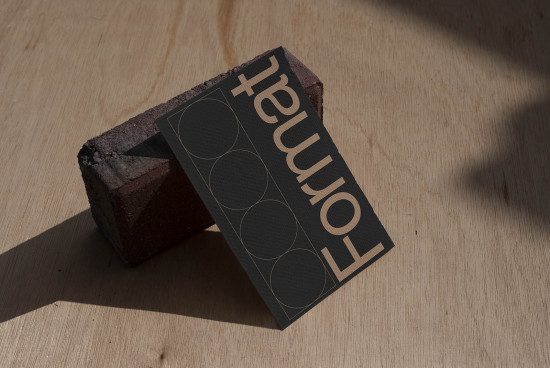 Elegant business card mockup with minimal design and shadow on wooden surface, showcasing font and layout, perfect asset for designers.