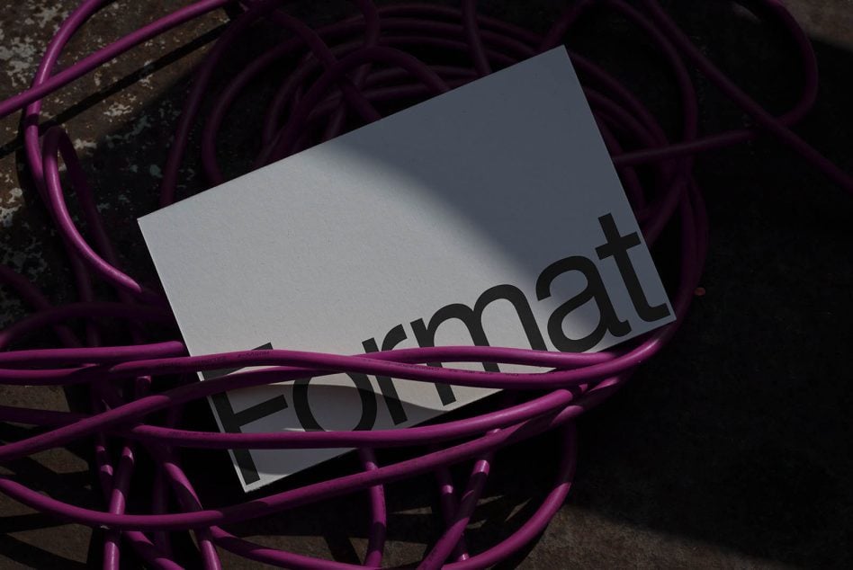 Format mockup card nestled among bright purple industrial cables on concrete