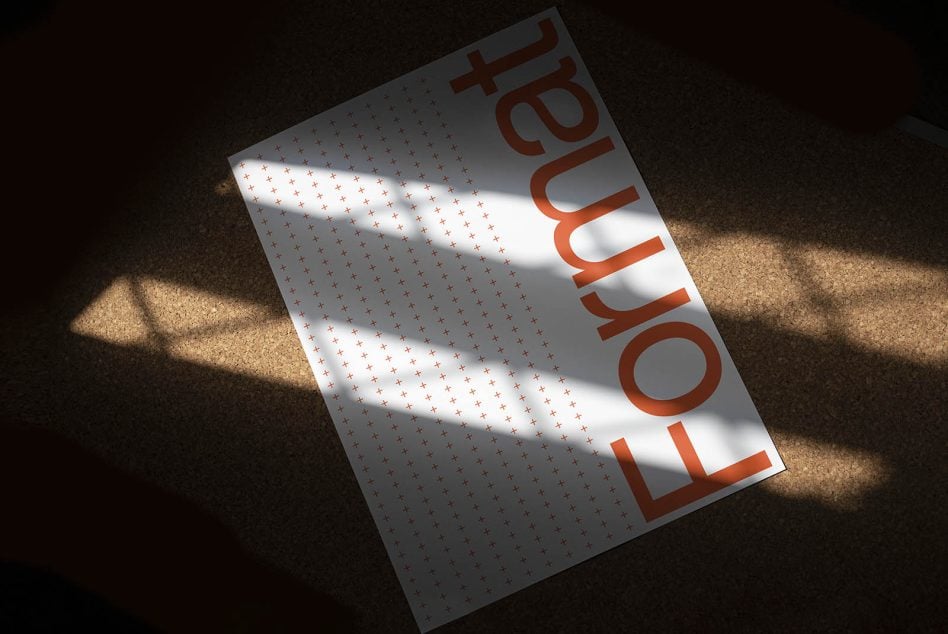 Minimalist white flyer with scattered small red marks, large orange type