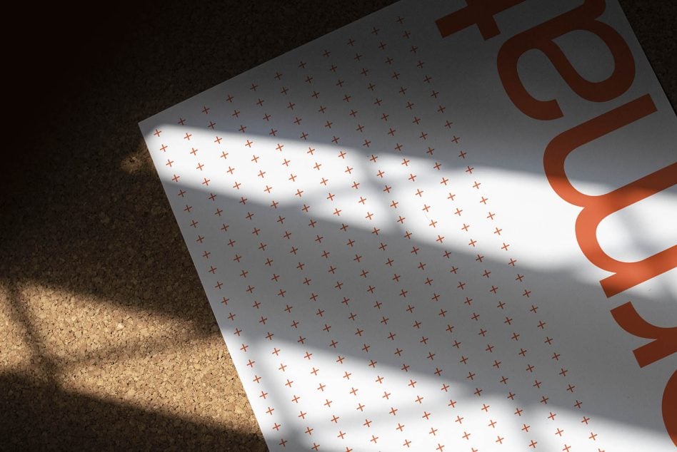White page with small red cross pattern, orange Sans Serif type visible