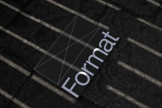 Realistic business card mockup on textured pavement with shadows for graphic designers presentation needs.
