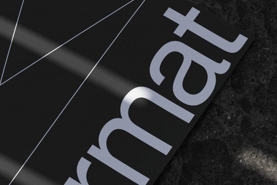 Close-up of modern sans-serif font mockup with sleek design, displayed on paper with dramatic lighting on textured backdrop for visual designers.
