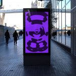 Outdoor digital billboard mockup with purple chef graphic in urban setting, perfect for designers to showcase advertising designs.