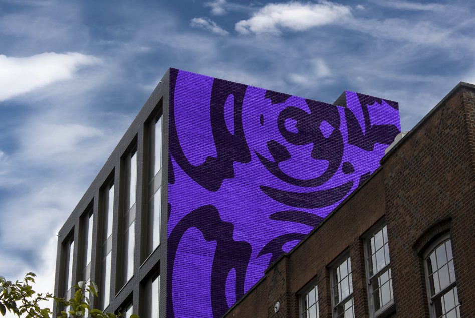 Vibrant purple neon sign on modern brick building facade with cloud sky