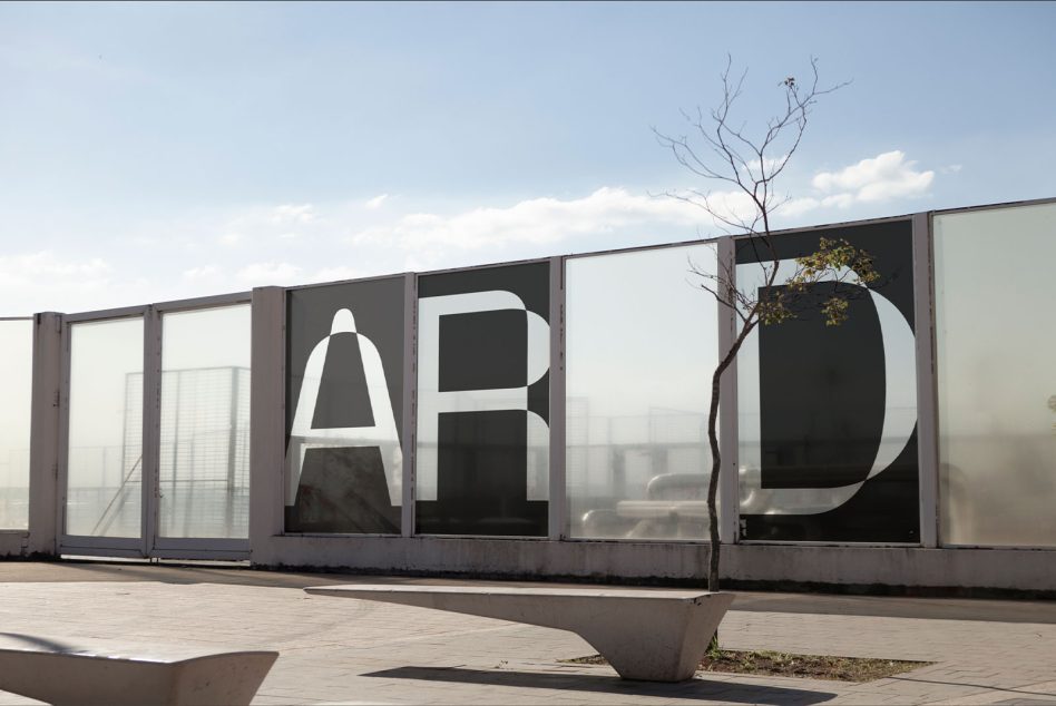 Urban outdoor billboard mockup with large lettering, clear sky backdrop, and a lone tree for graphic display, advertising, and design presentation.