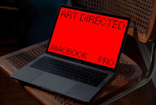 Laptop with red screen mockup on wicker chair, realistic digital device design asset for presentations, modern tech editable template.
