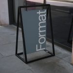 Outdoor signage mockup with a sleek design displayed on a sidewalk for branding and logo presentation, in an urban setting, clear visibility.