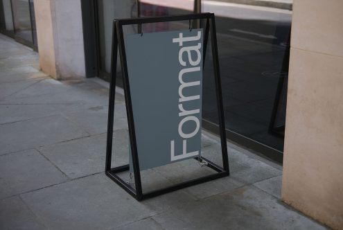 Outdoor signage mockup with a sleek design displayed on a sidewalk for branding and logo presentation, in an urban setting, clear visibility.