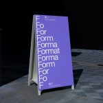 Outdoor mockup of a purple signage board with progressive typography design, showcased in urban setting for graphic designers.