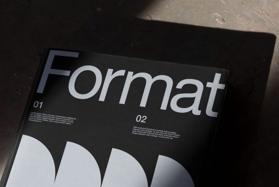 Close-up of a magazine mockup highlighting bold typography design, placed on a textured surface with shadows, ideal for presentations and portfolios.