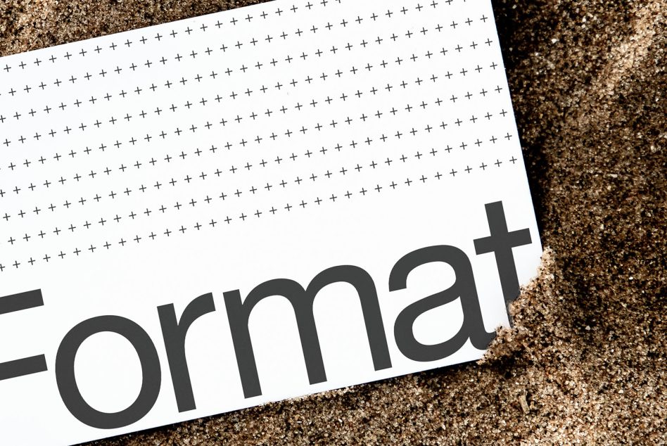 White paper with plus sign pattern on sand background showing partial text
