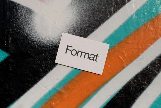 Business card mockup with 'Format' text on textured spray-painted surface in bright colors, ideal for designers looking for urban style graphics.