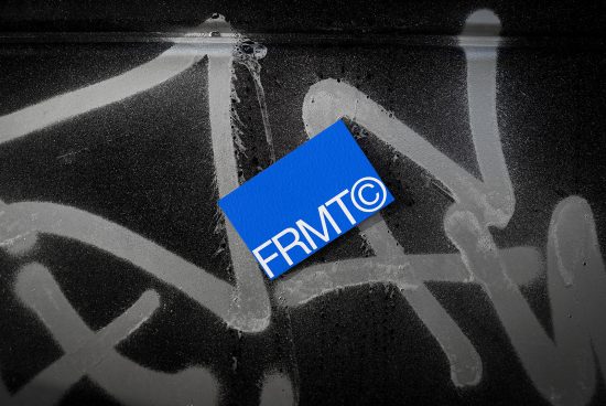 Blue business card with modern design on textured graffiti background, showcasing mockup for branding identity in urban setting.