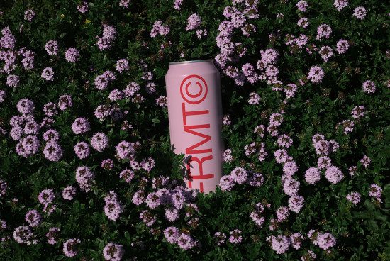 Beverage can mockup with branding on purple flowers background for product design presentation in garden setting.