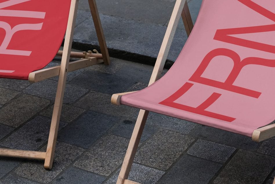Close up of colorful beach deck chairs with wooden frames on pavement, angled view