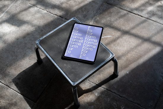 Digital tablet mockup on metal stool showcasing font design, natural lighting, modern display for graphic designers and typographers.