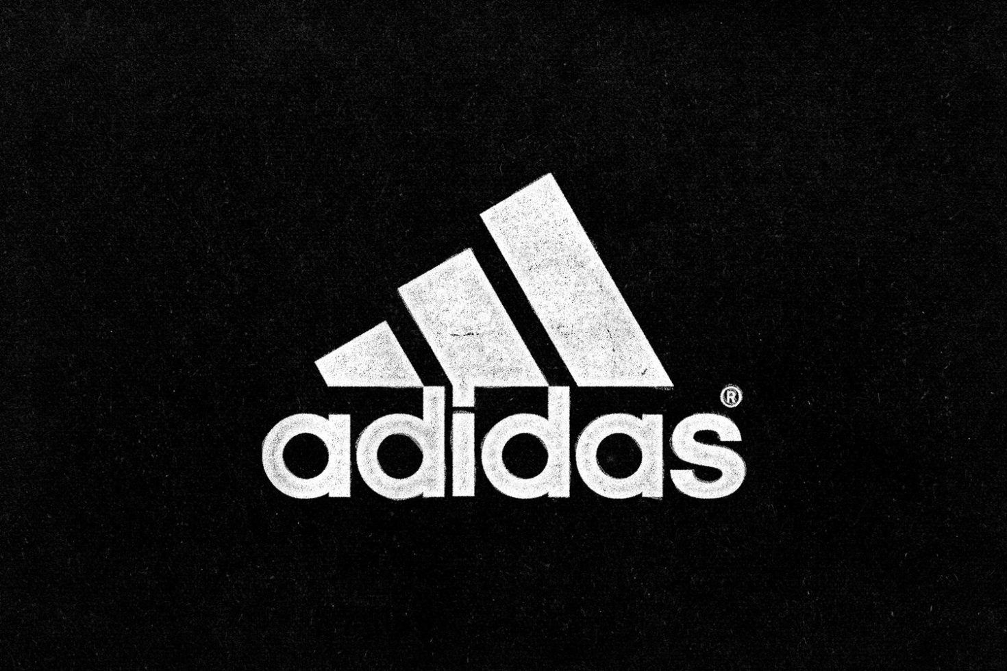 Vintage textured Adidas logo on dark background for graphic design inspiration and apparel mockups.