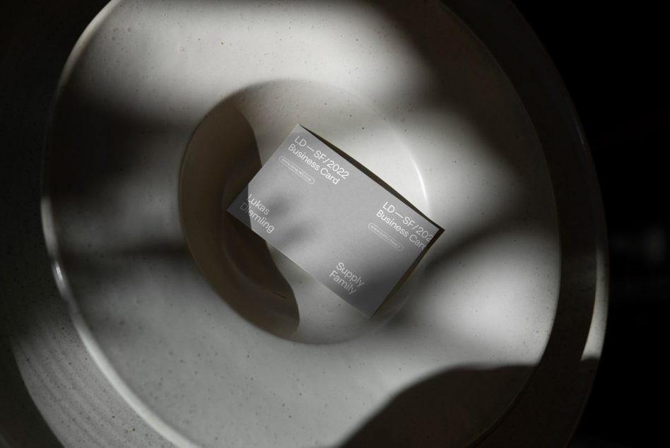 Elegant business card mockup on a ceramic dish, with dramatic lighting to showcase design and texture. Ideal for presentations, branding, and portfolio.