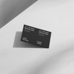 Elegant black and white business card mockup on a geometric background, showcasing professional design layout for branding and identity.