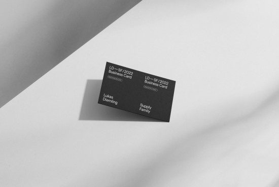 Elegant black and white business card mockup on a geometric background, showcasing professional design layout for branding and identity.