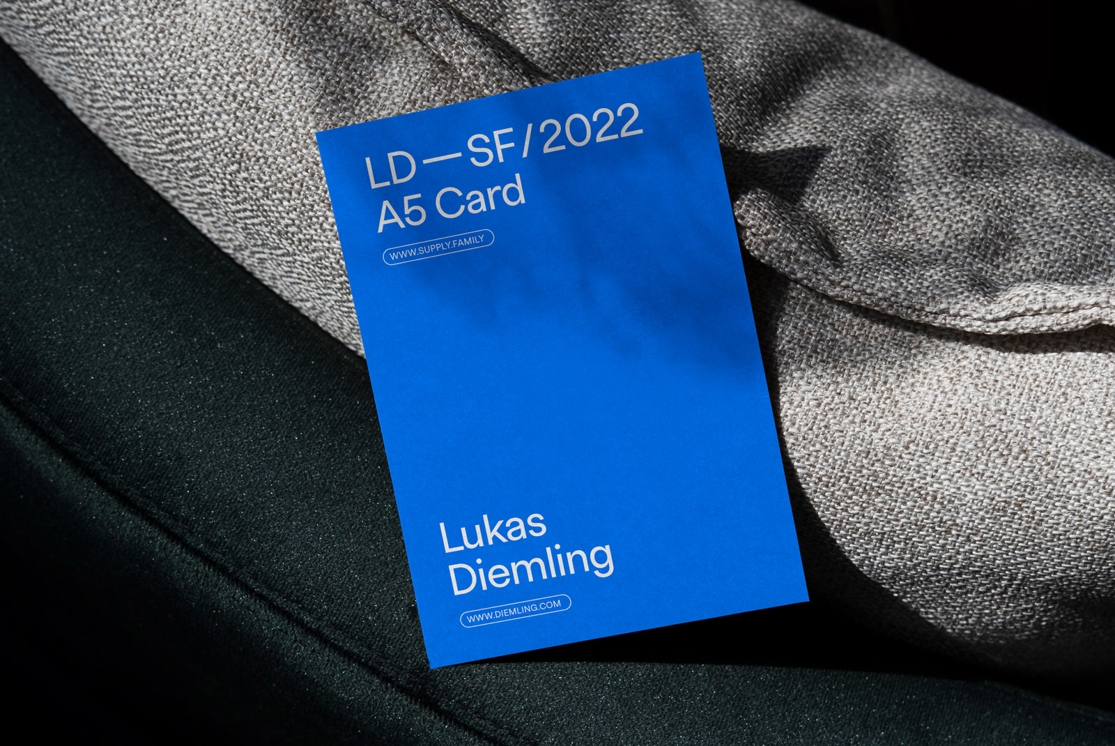Blue A5 card mockup with text, situated on a textured fabric surface. Ideal for presentations and branding for designers.