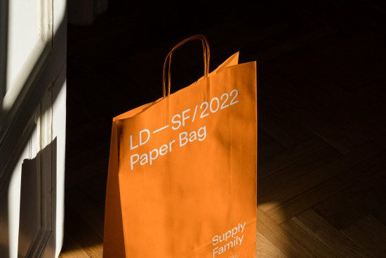 Elegant paper bag mockup with dramatic lighting on wooden floor, ideal for showcasing branding and packaging designs.