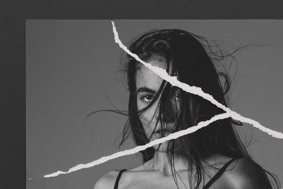 Black and white portrait with white torn paper diagonal lines across face