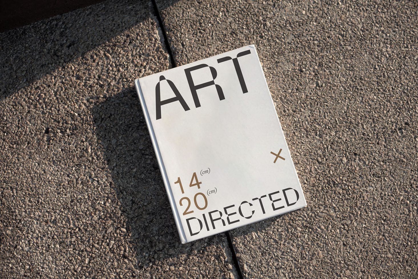 Magazine mockup with 'ART' cover design on textured pavement, ideal for presenting editorial designs to clients.