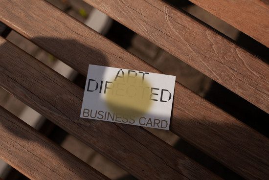 Business card mockup on wooden slats with natural shadows, perfect for showcasing design work and branding presentations for designers.