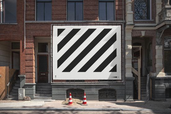 Urban billboard mockup with diagonal black stripes on a white background in a brick building setting for outdoor advertising design display.