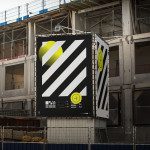 Billboard mockup on a construction site displaying a bold graphic design with yellow accents, ideal for presenting outdoor advertising designs.