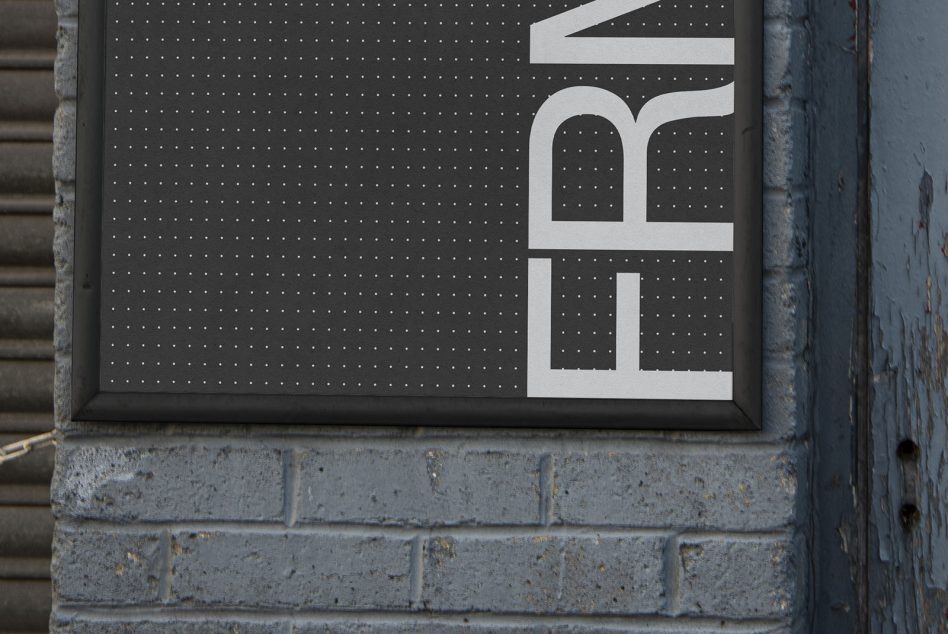 Dark pegboard sign with white letter forms, geometric shapes displayed