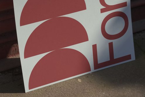 Bold red font poster design mockup leaning on a wall outdoors, showcasing modern typography for graphic templates, advertising, and branding.