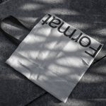 Canvas tote bag mockup with shadows on textured pavement, suitable for showcasing design and font work for designers.