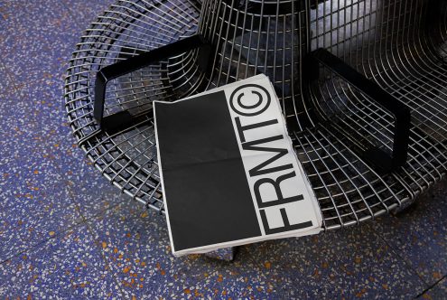 Stylish tote bag mockup with bold typography resting on a modern metal bench, showcasing urban design and fashion accessories.