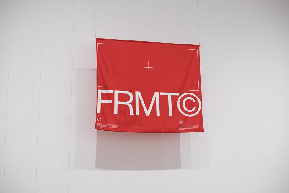 Red square fabric hanging from wall showing FRMT© logo with corner brackets