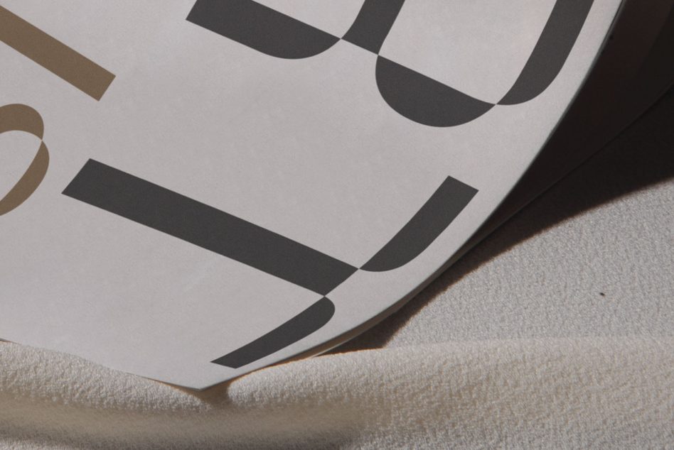 Angled overhead shot of printed paper with geometric shapes in black, tan, on linen texture