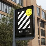 Outdoor billboard mockup with a black design and yellow icon, displayed in an urban environment, perfect for designers, urban advertising graphics.