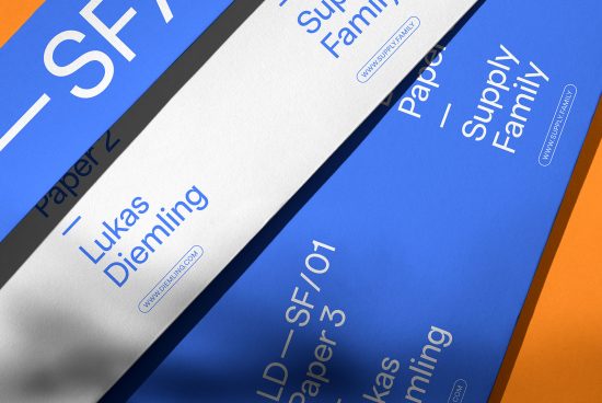 Close-up view of modern font design on paper mockups with vibrant blue and orange colors, showcasing typography and branding elements for designers.