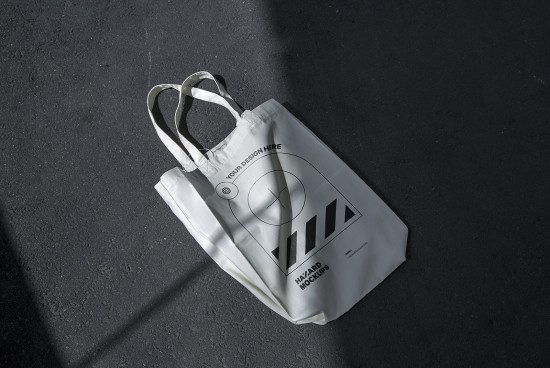 White tote bag mockup on asphalt for design showcase, featuring editable branding area, suitable for graphic designers and brand presentations.